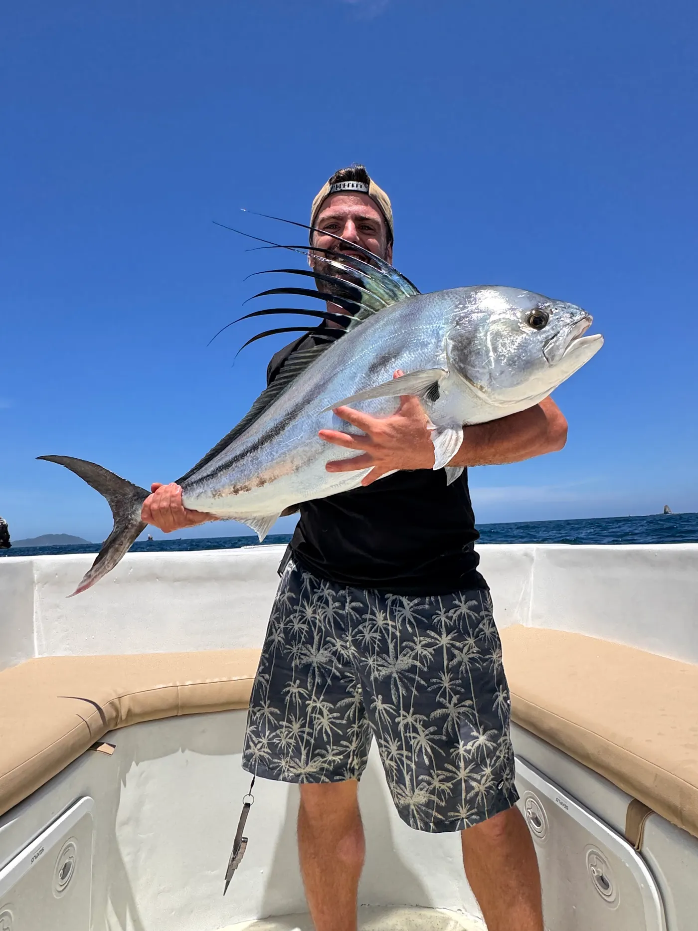 An angler holding a rooster fish caught off Playa Flamingo