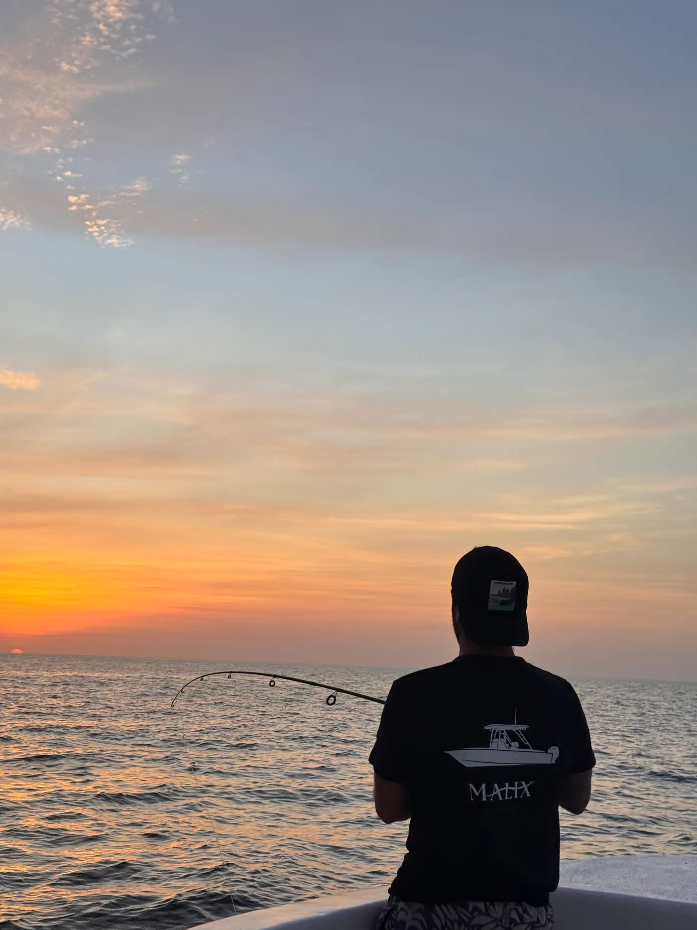 A guest watching the sunset over the Pacific from the Malix boat